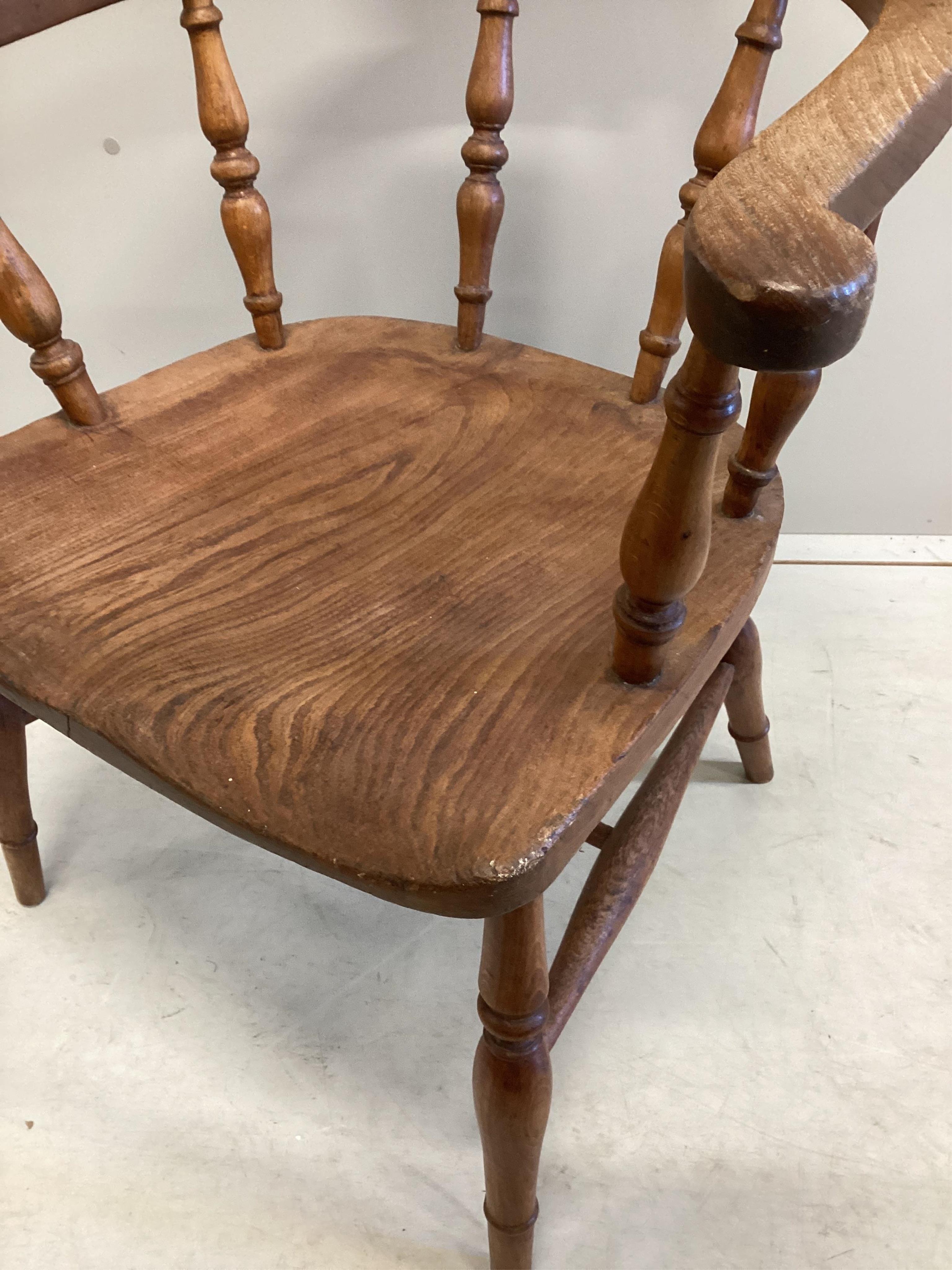 A Victorian elm and beech smoker's bow elbow chair on slender turned baluster legs with H stretcher, width 62cm, depth 45cm, height 78cm. Condition - good, timber slightly faded.